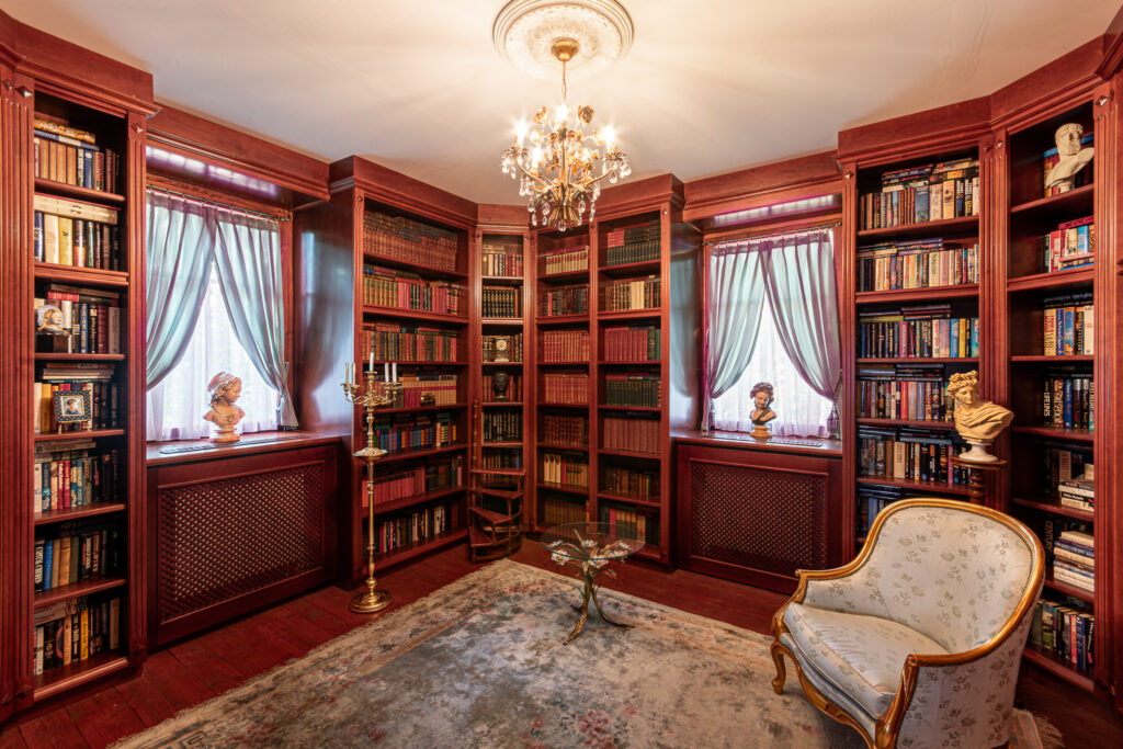 Biblioteka w Pałacu Goworów z drewnianymi regałami i fotelami.