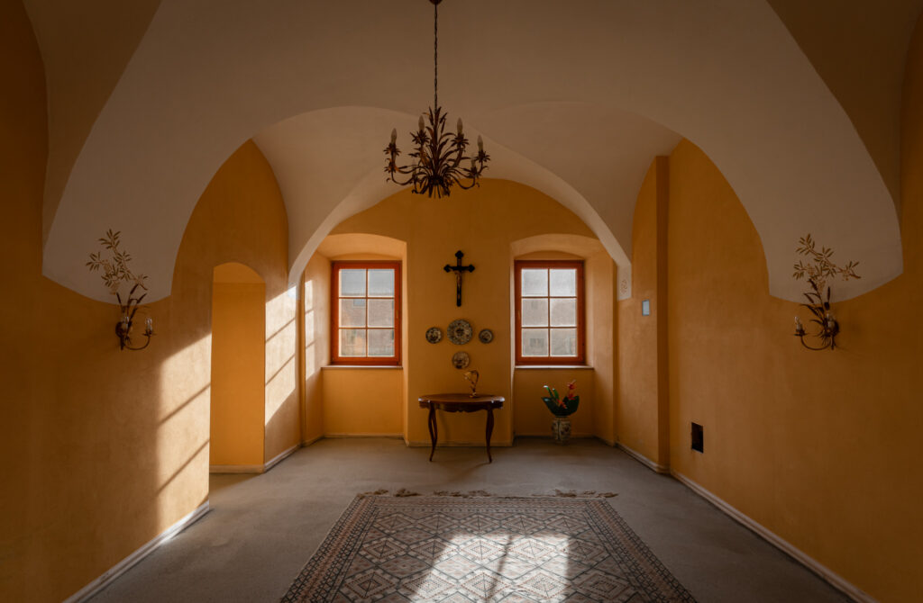 Jasna, sklepiona sala w Pałacu Goworów z drewnianymi drzwiami.